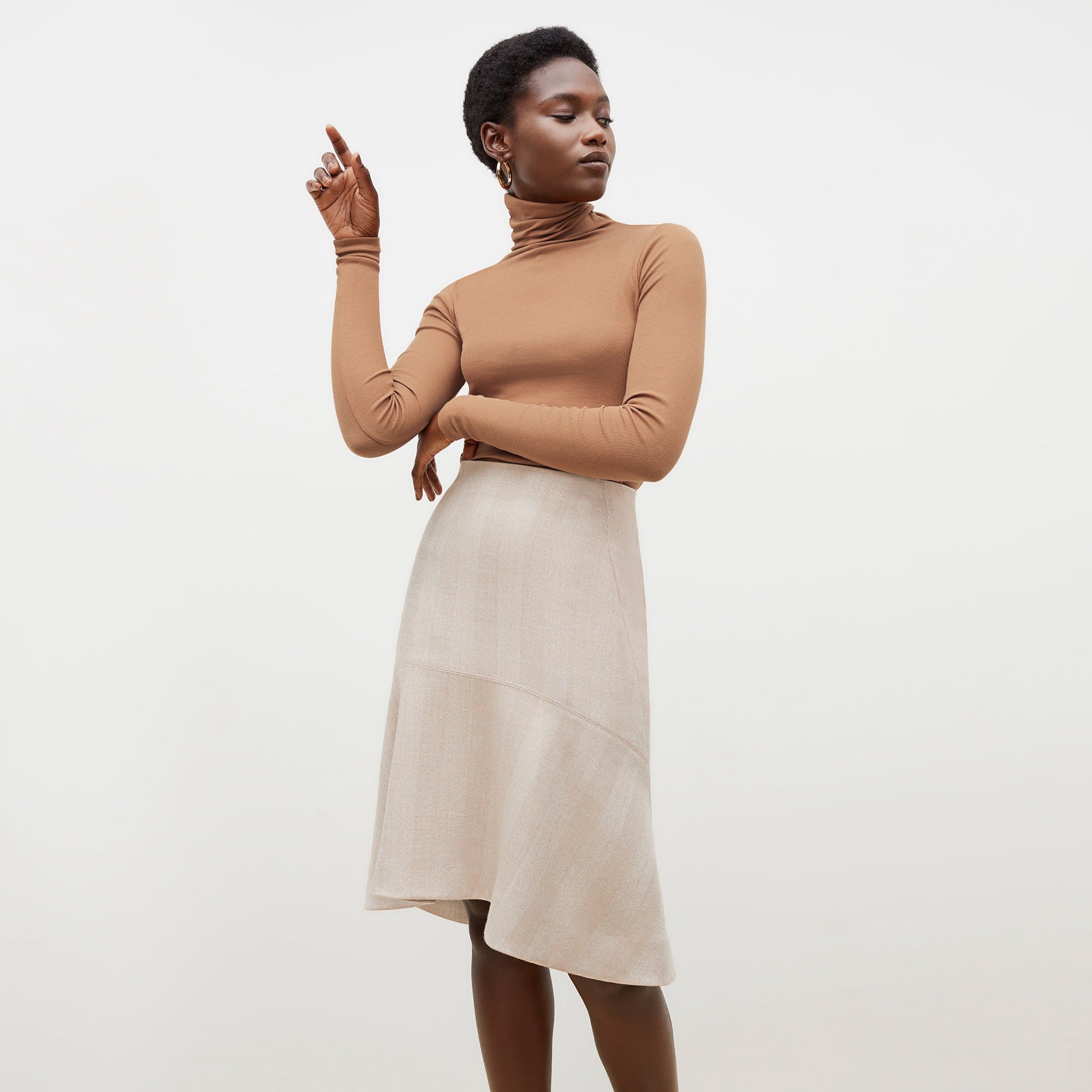 Front image of a woman standing wearing the axam top in camel | Exclude