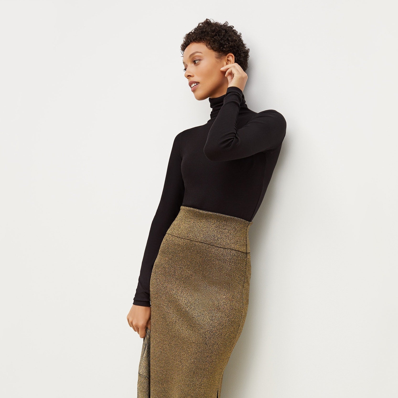 Front image of a woman standing wearing the axam top in black | Exclude
