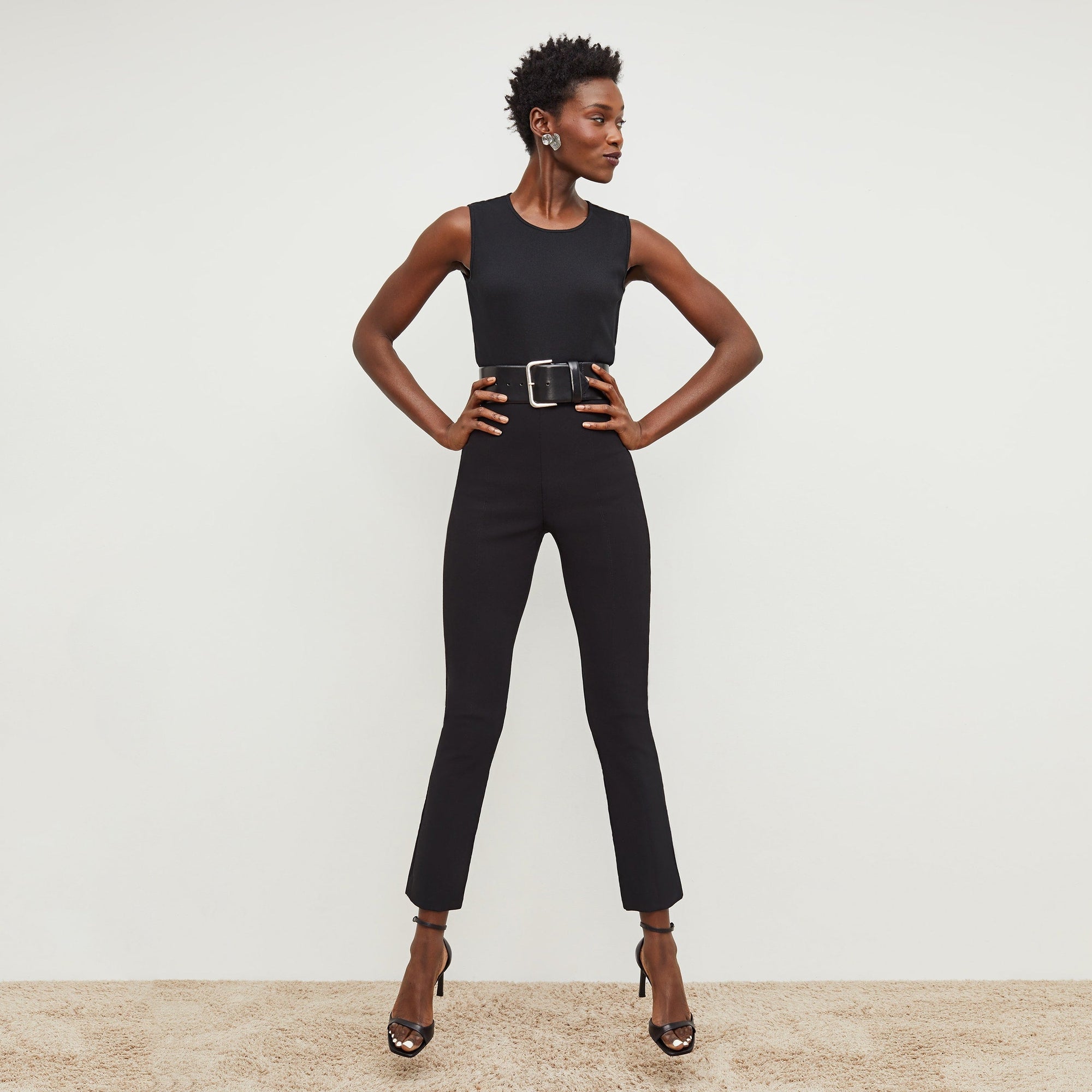 Front image of a woman standing wearing the Foster Pant—Everstretch in Black | Exclude