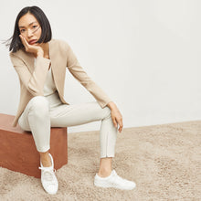 Side image of a woman standing wearing the Curie Pant—Everstretch in Bone