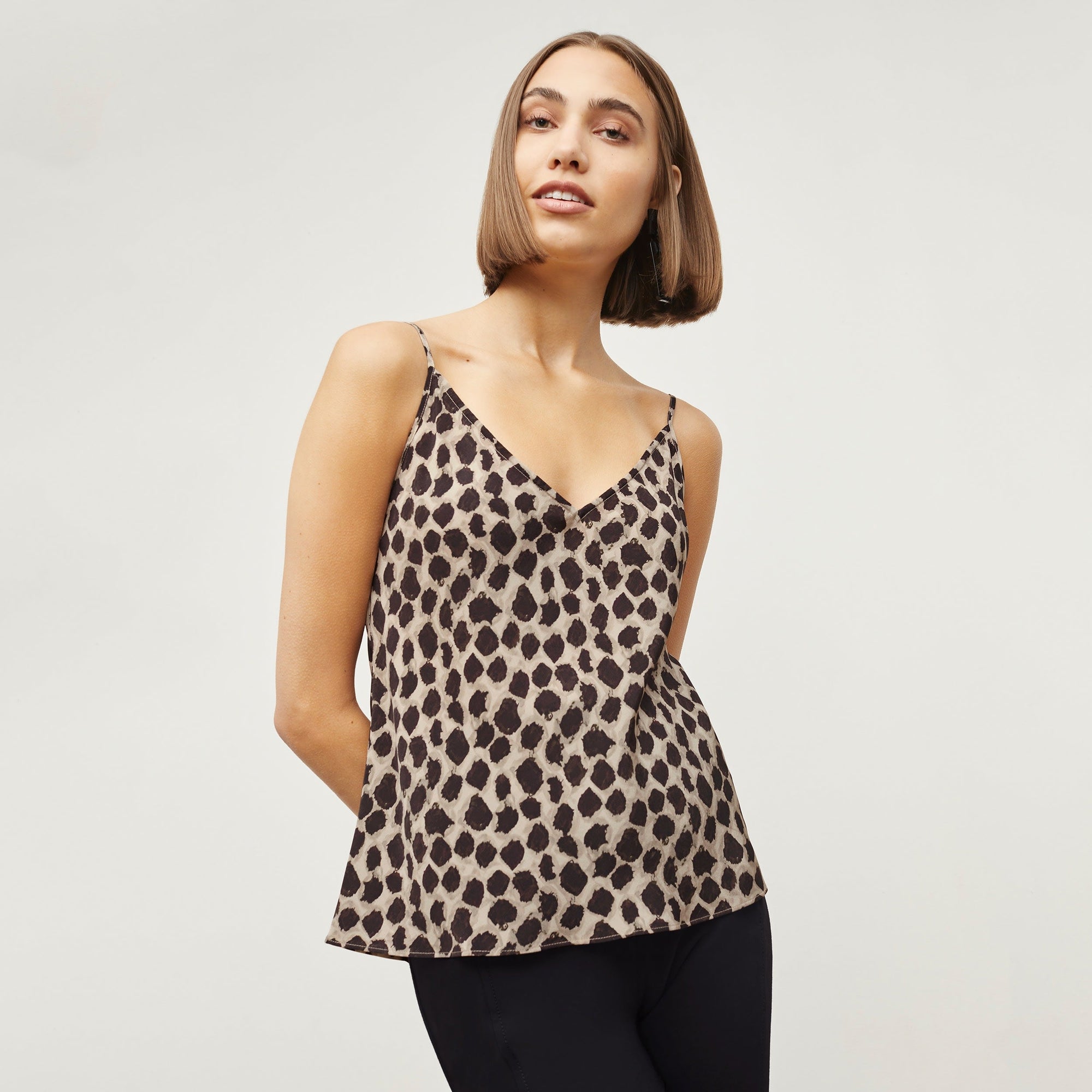 Front image of a woman standing wearing the Lisey Cami—Sahara Print Washable Silk in Tan/Black | Exclude