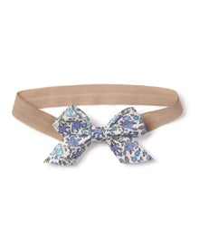 The Girls Twill Hair Bows in Fleur DAzur by Petite Plume feature charming fabrics with an elastic beige band and a decorative bow adorned with a blue and black floral pattern on white. This delightful accessory adds an enchanting touch to any girls ensemble.
