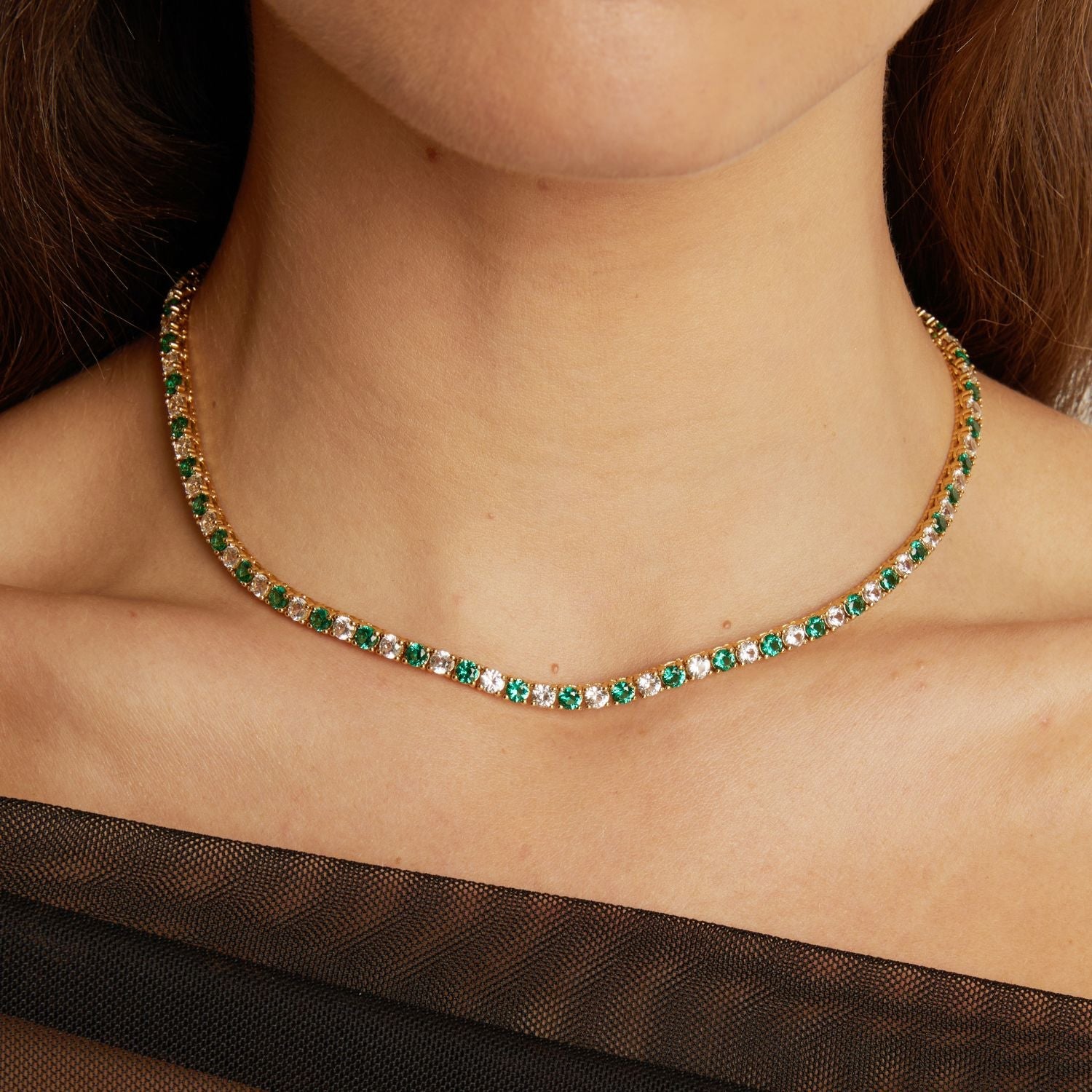 Necklace with green gemstones worn by a person