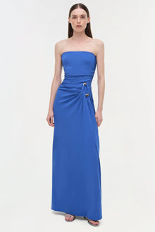 Blue strapless floor-length gown with draped side detail and gold embellishment at waist.