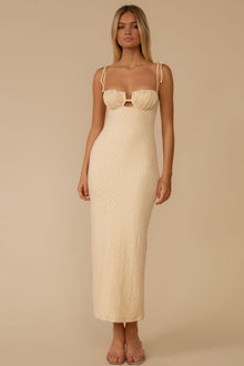 Cream textured long slip dress with cutout bust detail and adjustable shoulder straps on model.