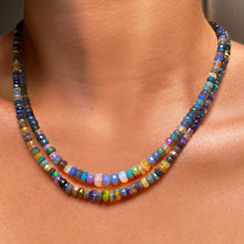 Shimmering beaded necklace made of faceted opals in shades of light blue, light purple, yellow, white, and clear on a gold linking ovals clasp.