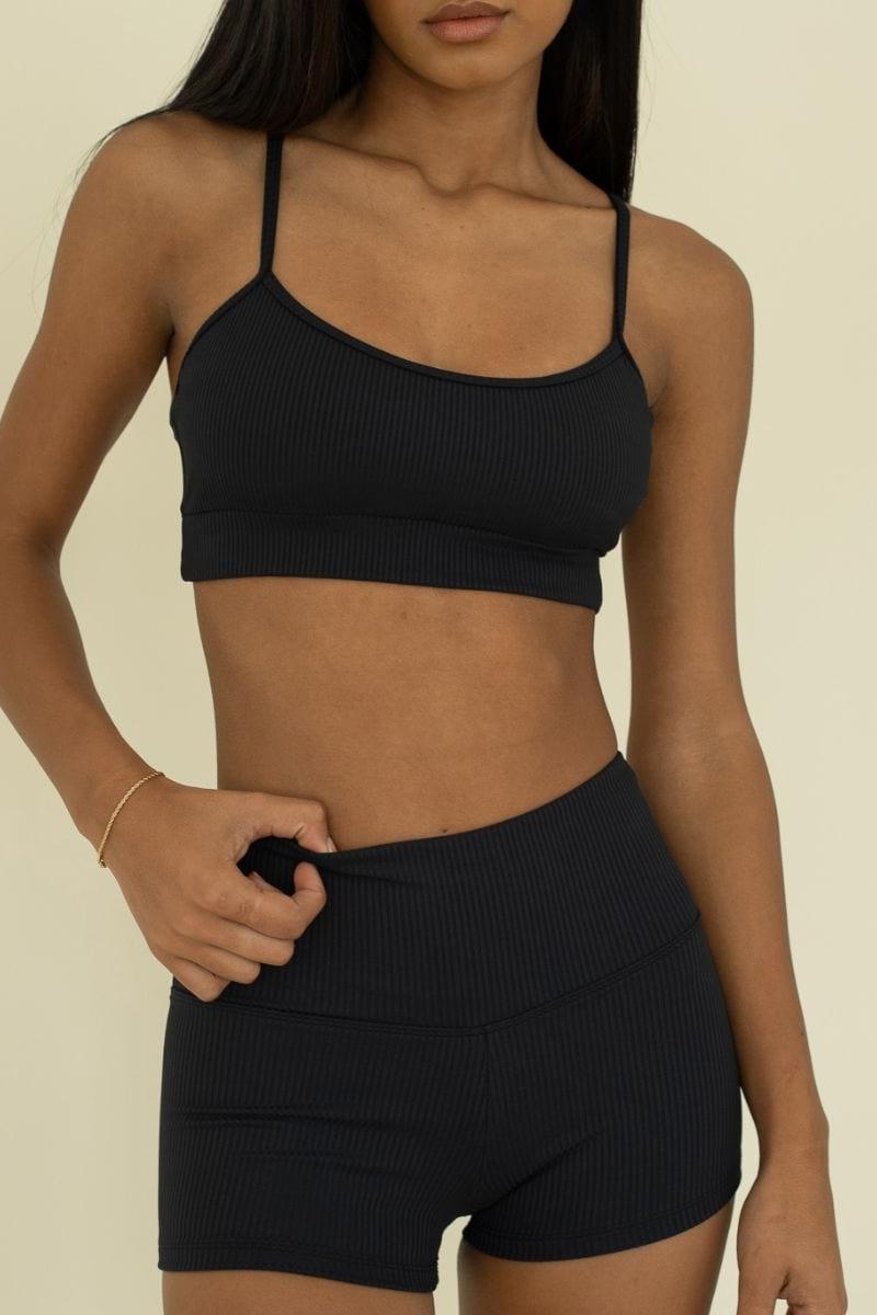 Black ribbed micro shorts with high waistband and matching camisole top on model.