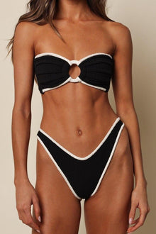 Black thong bikini bottom with cream-colored binding and textured terry rib fabric.