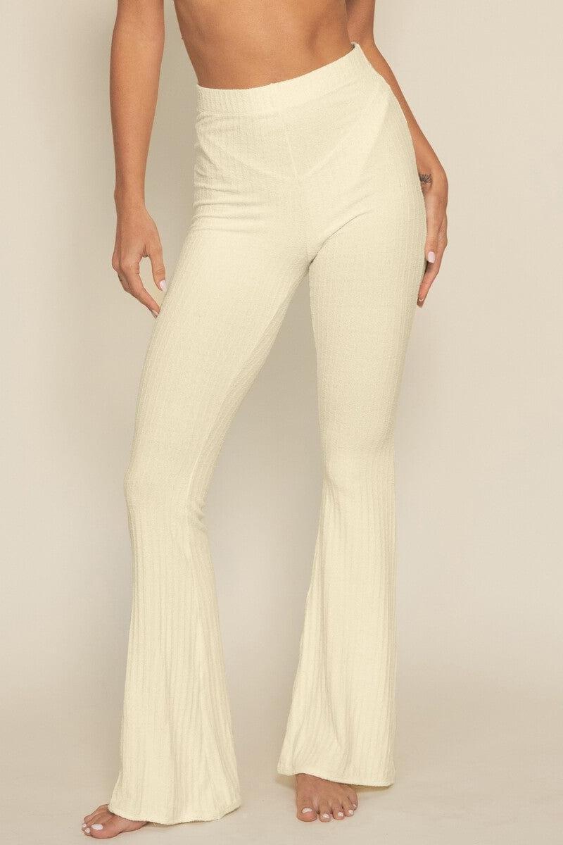 Cream ribbed flare pants with high waist and wide legs shown on model against neutral background.