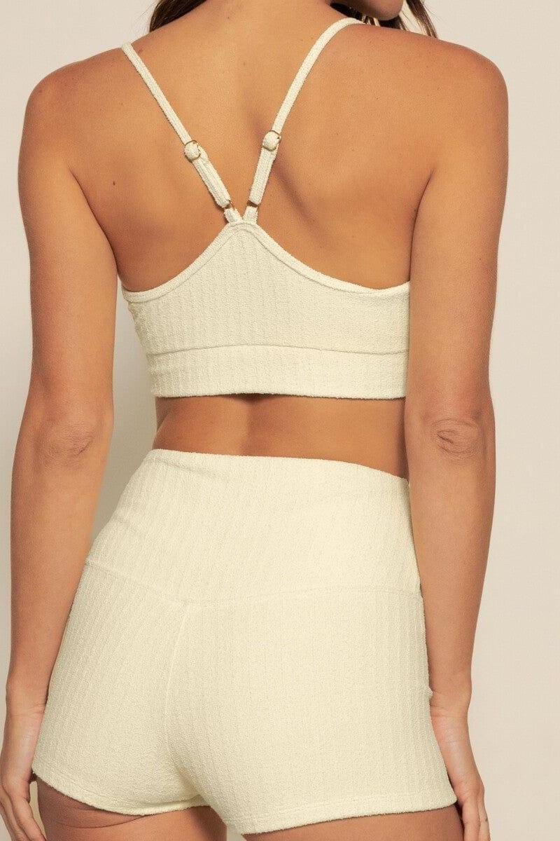Cream ribbed crop top with adjustable straps and matching shorts, shown from back view.