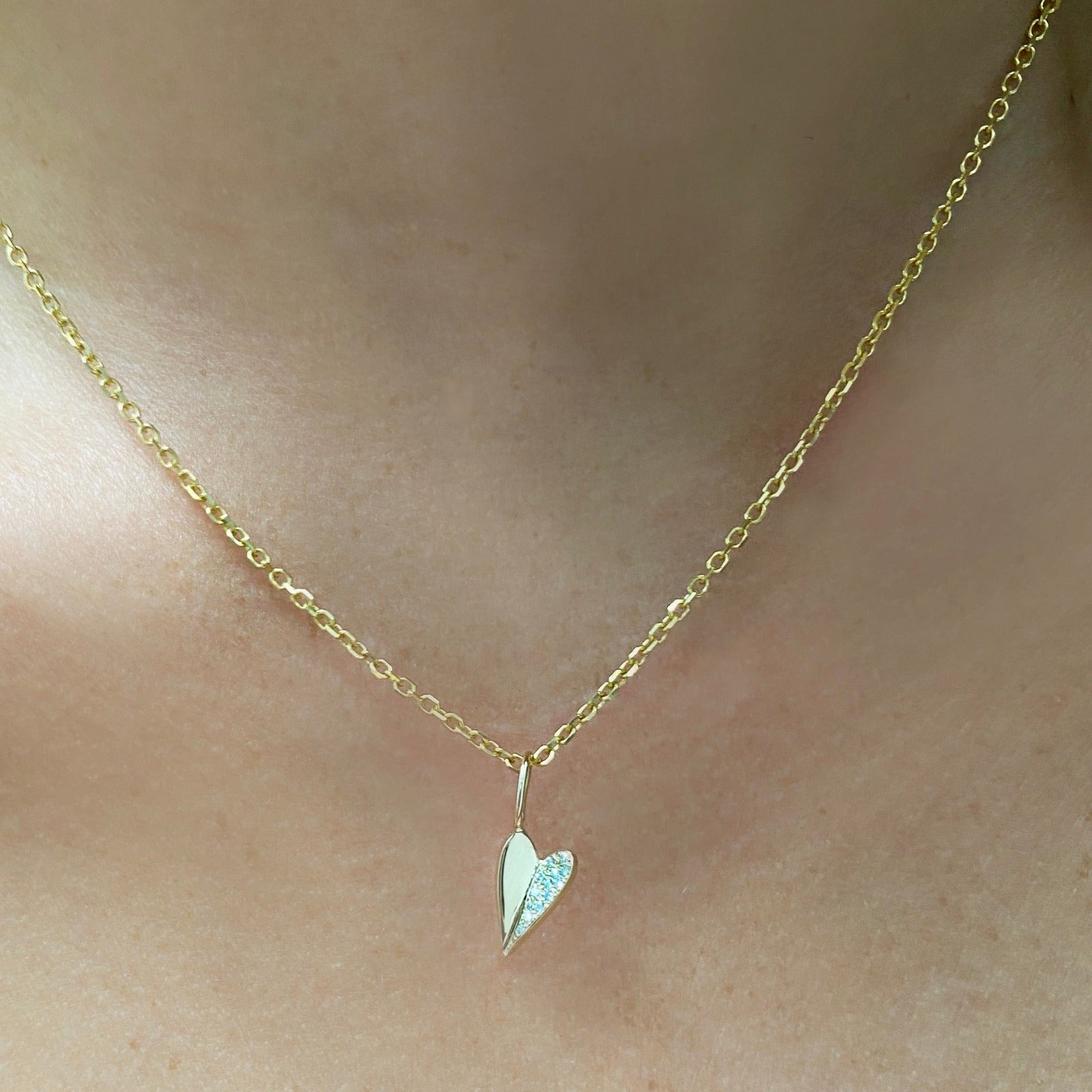 14k white gold small folded heart charm with pave diamonds on the right side.