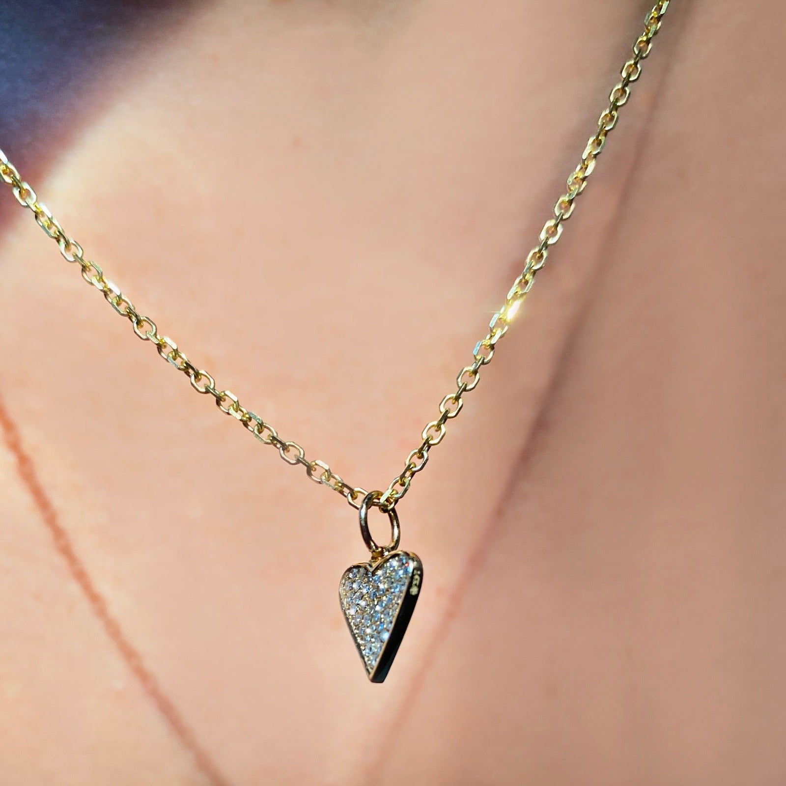 14k gold Diamond Cut Cable Chain Necklace. Styled on a neck with a pave heart charm