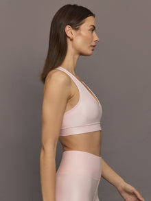 Model wears a v neck baby pink bra in a liquidy takara shine finish. 