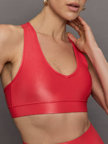 Model wears a v neck bright red bra in a liquidy takara shine finish. 
