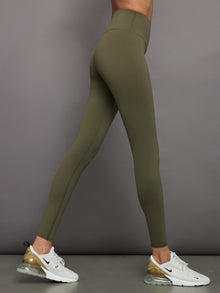 Model wears full-length olive leggings with a high-rise wide waistband and smooth, compressive fabric.