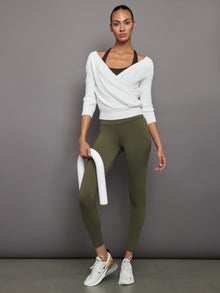 Model wears full-length olive leggings with a high-rise wide waistband and smooth, compressive fabric.