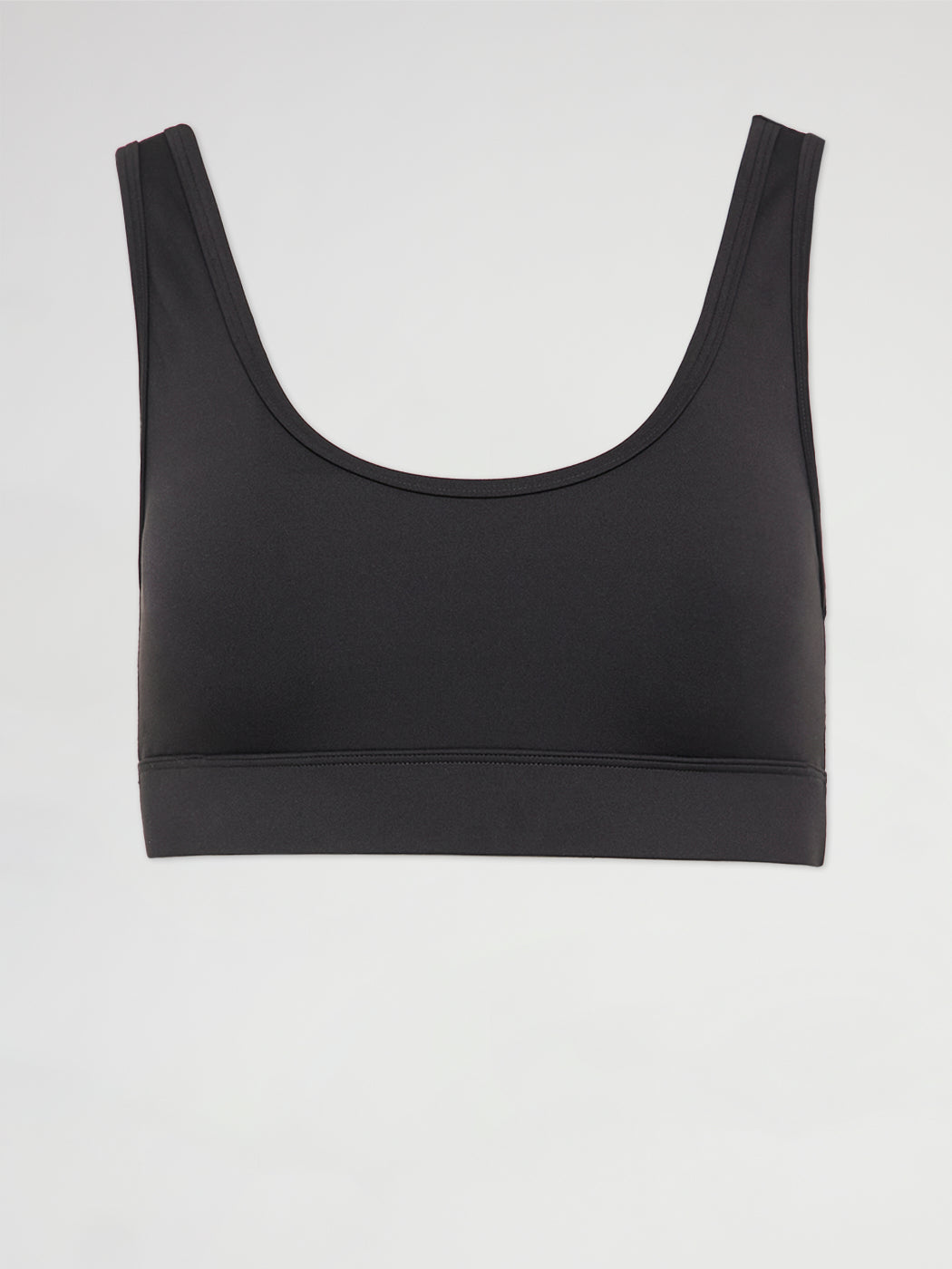 Flat lay of black scoop neck sports bra with cut out back design.