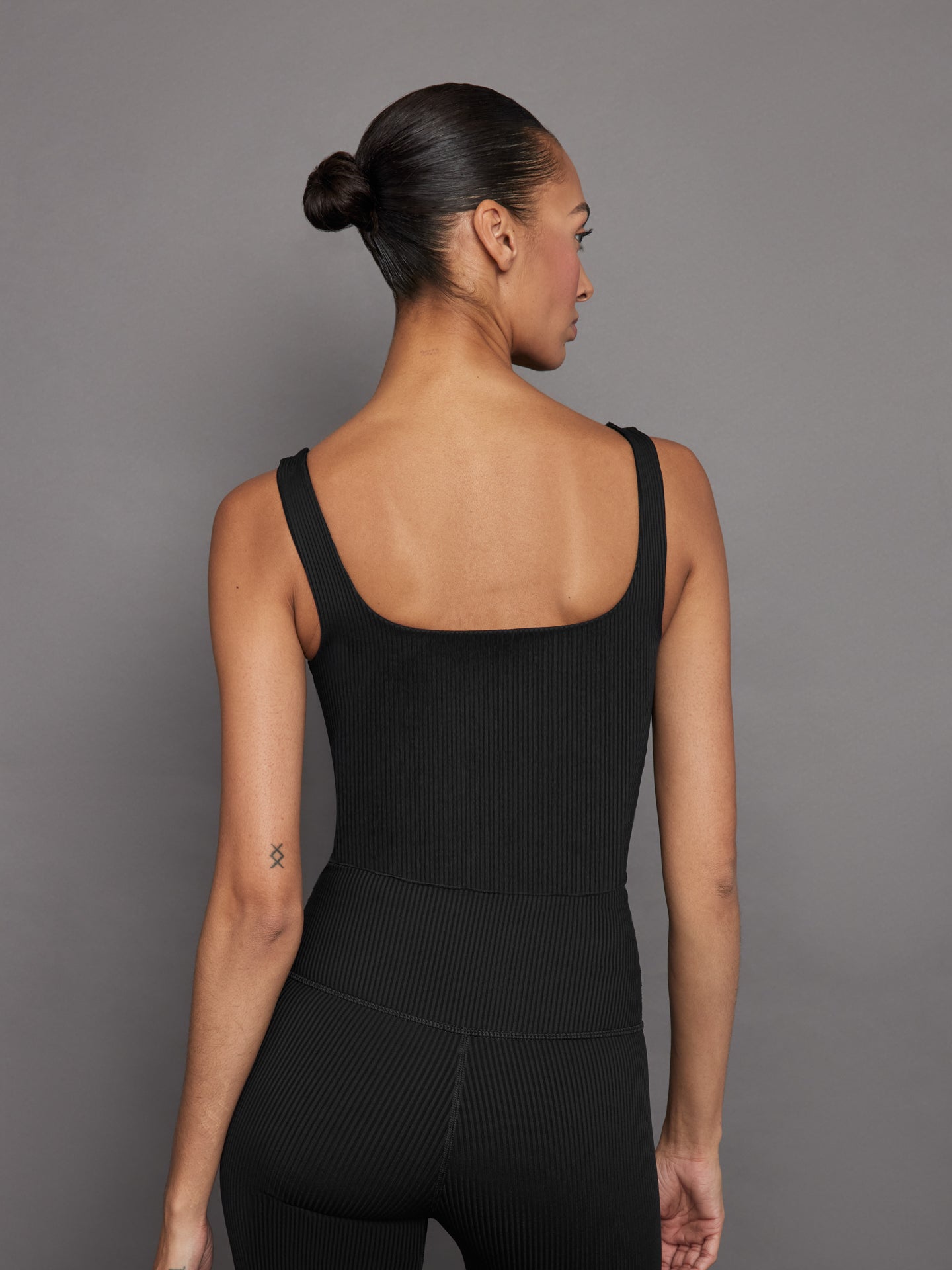 Back view of ribbed black cropped tank top showing scoop back.