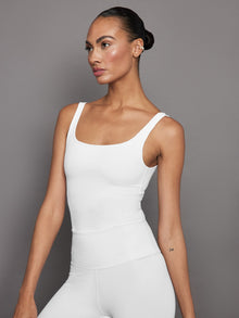 Model wearing white ribbed cropped tank, front angle view.