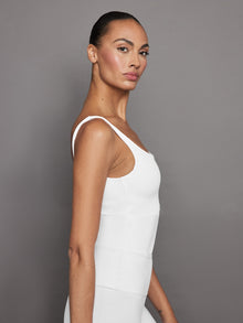 Side profile of model in white ribbed crop tank highlighting fit.