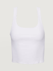 Flat lay of white ribbed cropped tank on neutral background.