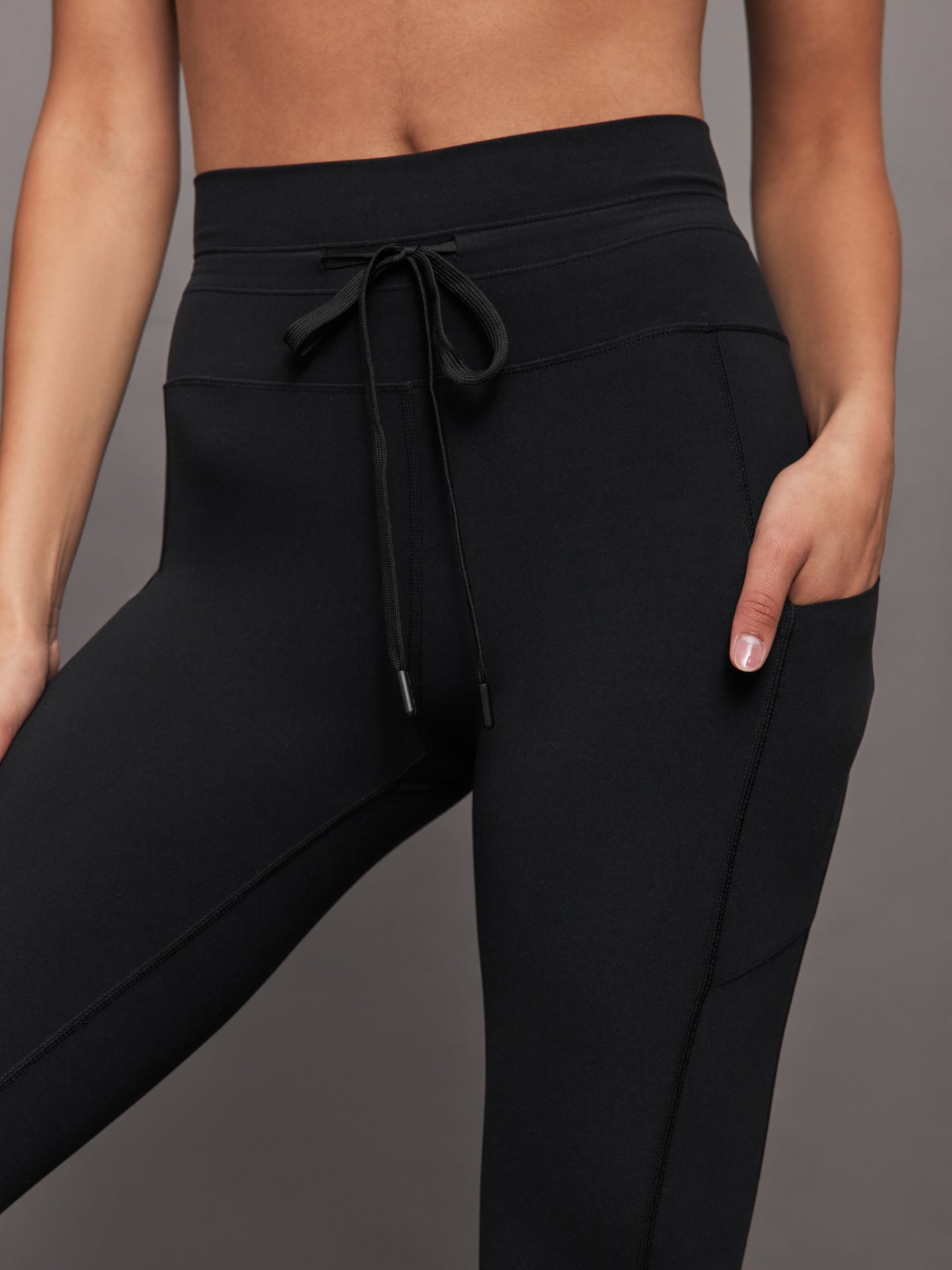 Close up of Melt High Rise Sport Pocket Legging Black waistband with drawcord and pocket detail.