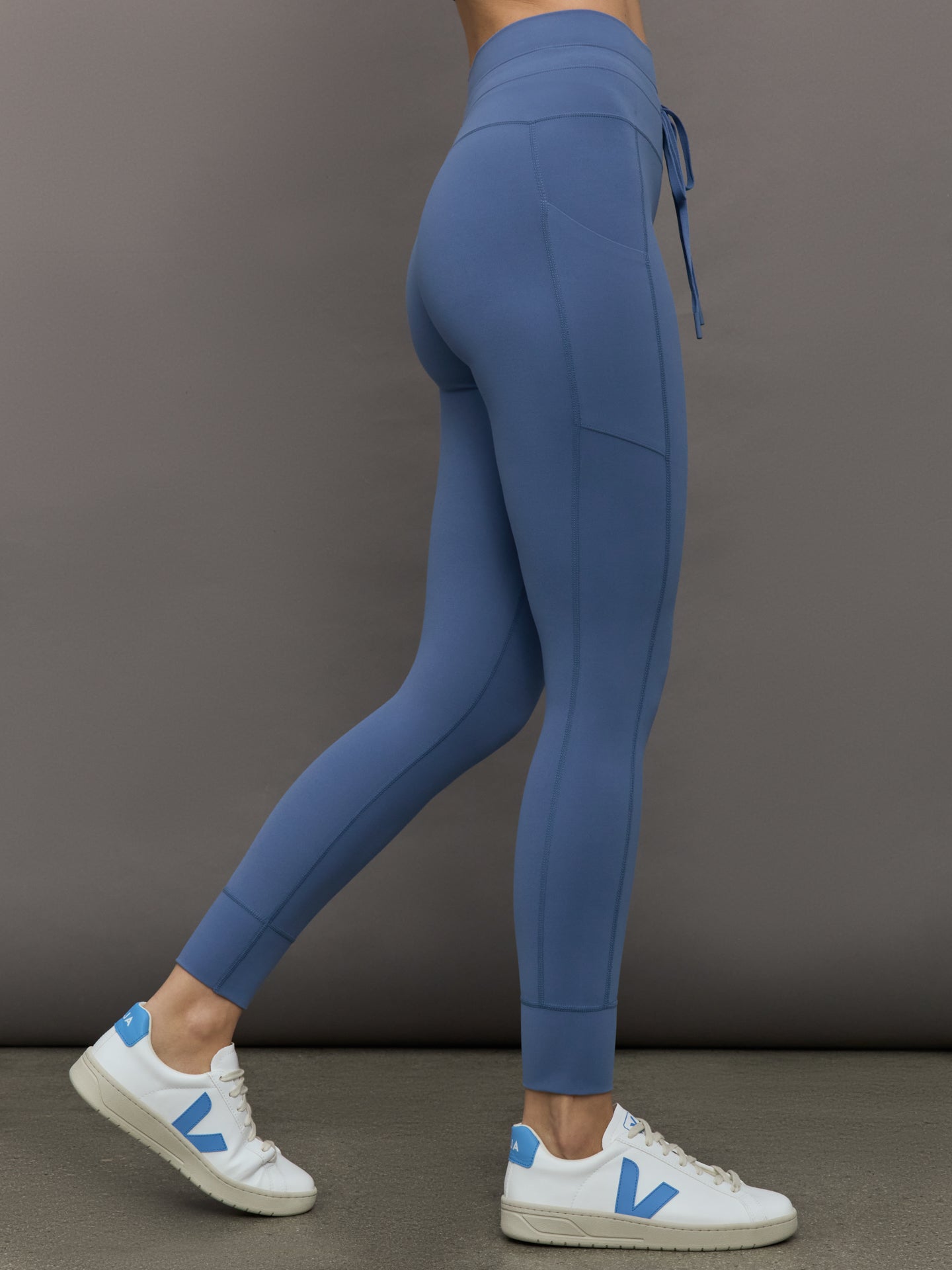 Model wears a periwinkle blue buttery soft pair of leggings with pockets and drawstring waist, perfect for all activities. 