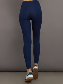 Model wears navy, high-rise leggings with a ribbed texture and a smooth, form-fitting silhouette.
