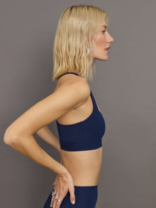 Side profile of ribbed Melt racerback bra in true navy on model.