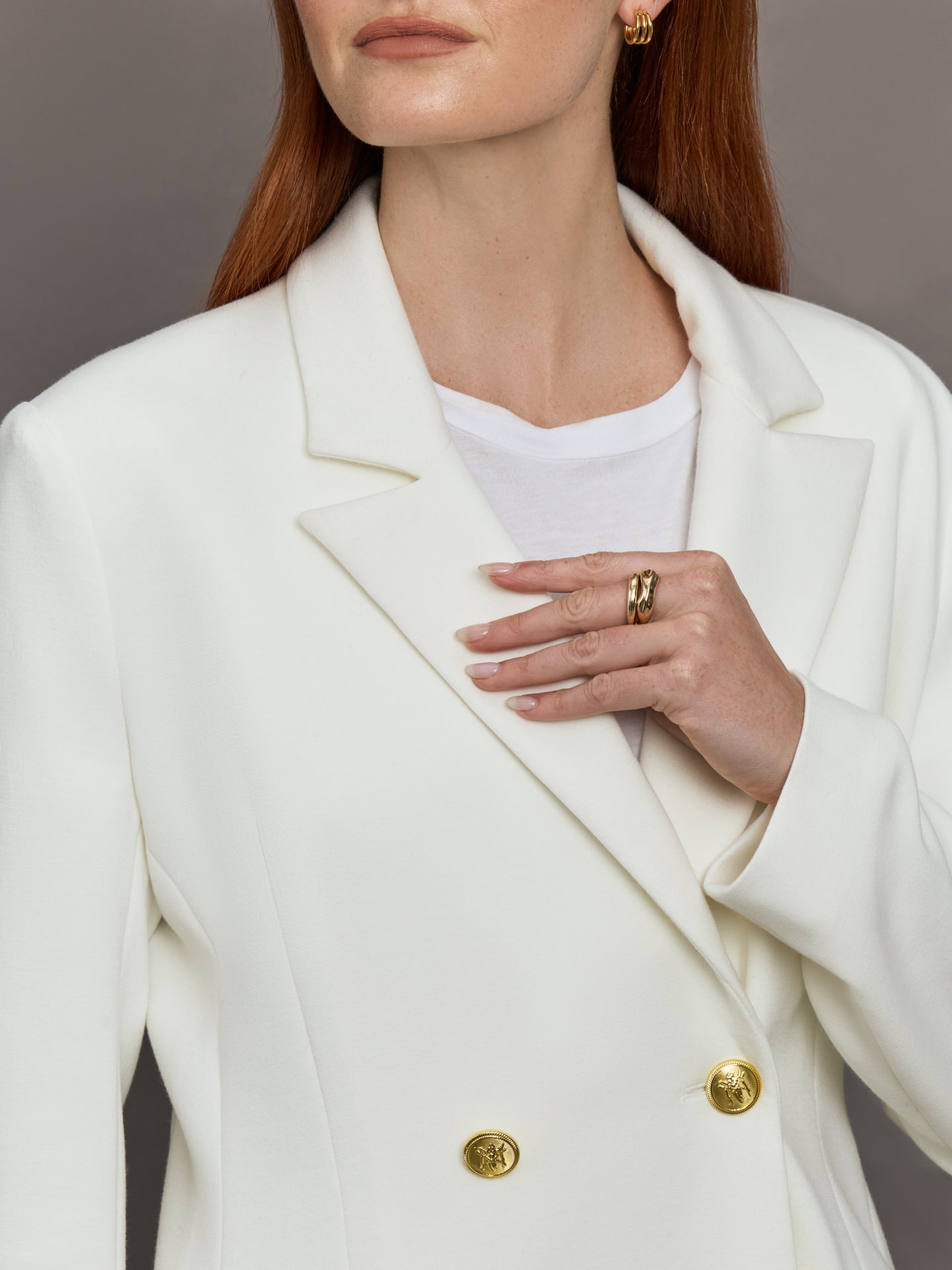 Model wears the white double-breasted blazer in Scuba, with a tailored fit, and a smooth, contoured finish.