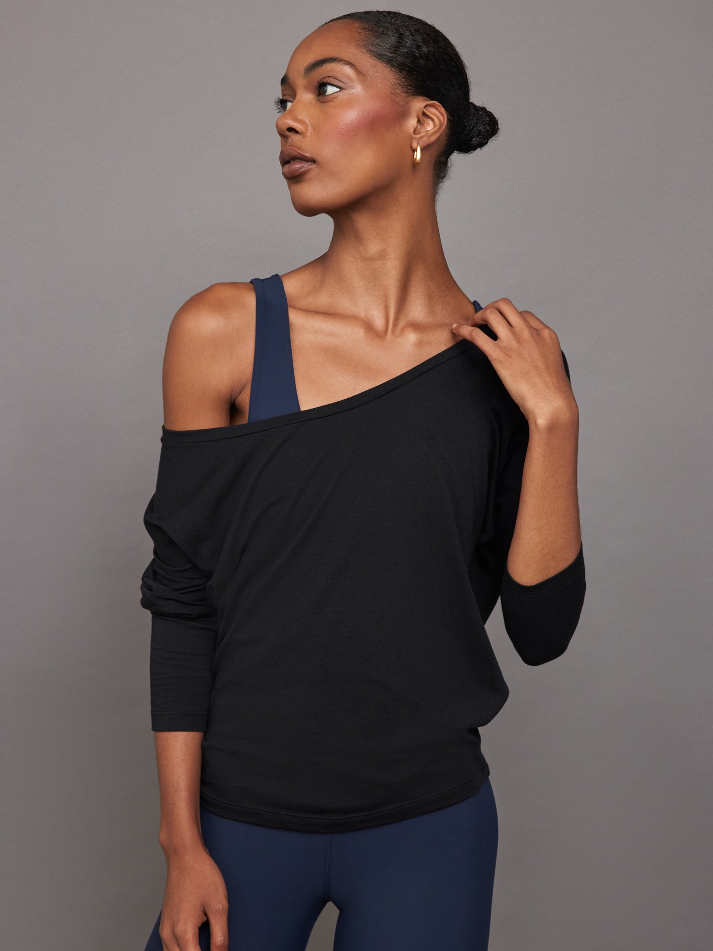 Front view of model wearing Long Sleeve Off Shoulder Tee Black with relaxed neckline.