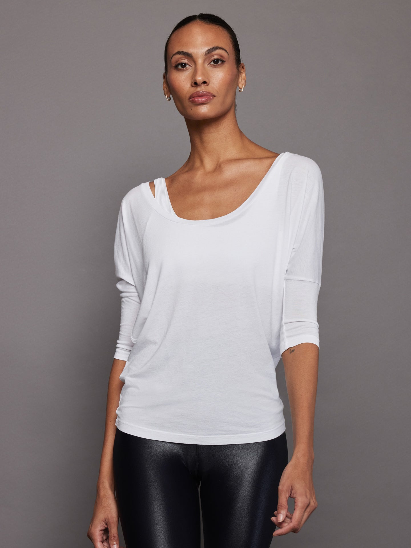 Model is wearing white off-shoulder tee with relaxed fit, front view.