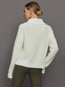 Model wears off white boucle pullover sweater with a half-zip front and high collar.