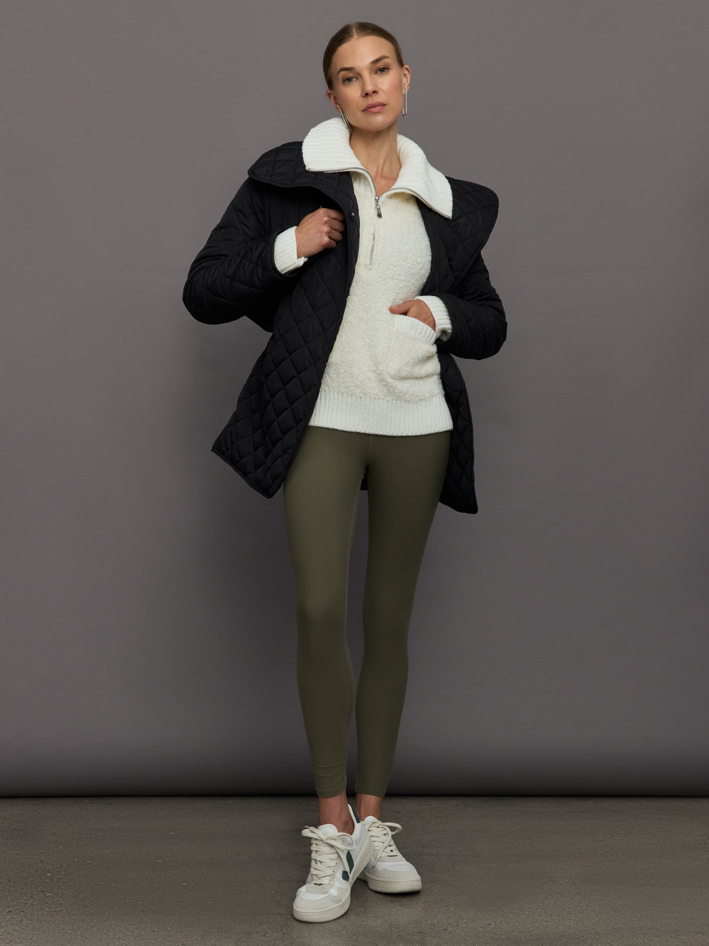 Model wears off white boucle pullover sweater with a half-zip front and high collar.