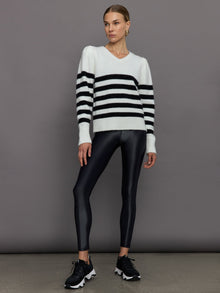 Model wears black and white striped sweater with v-neck.