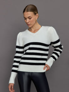 Model wears black and white striped sweater with v-neck.