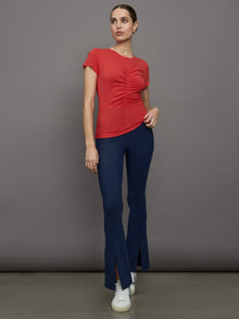 Model wears red short sleeve T-shirt with ruching down the center of the chest until the belly button. 