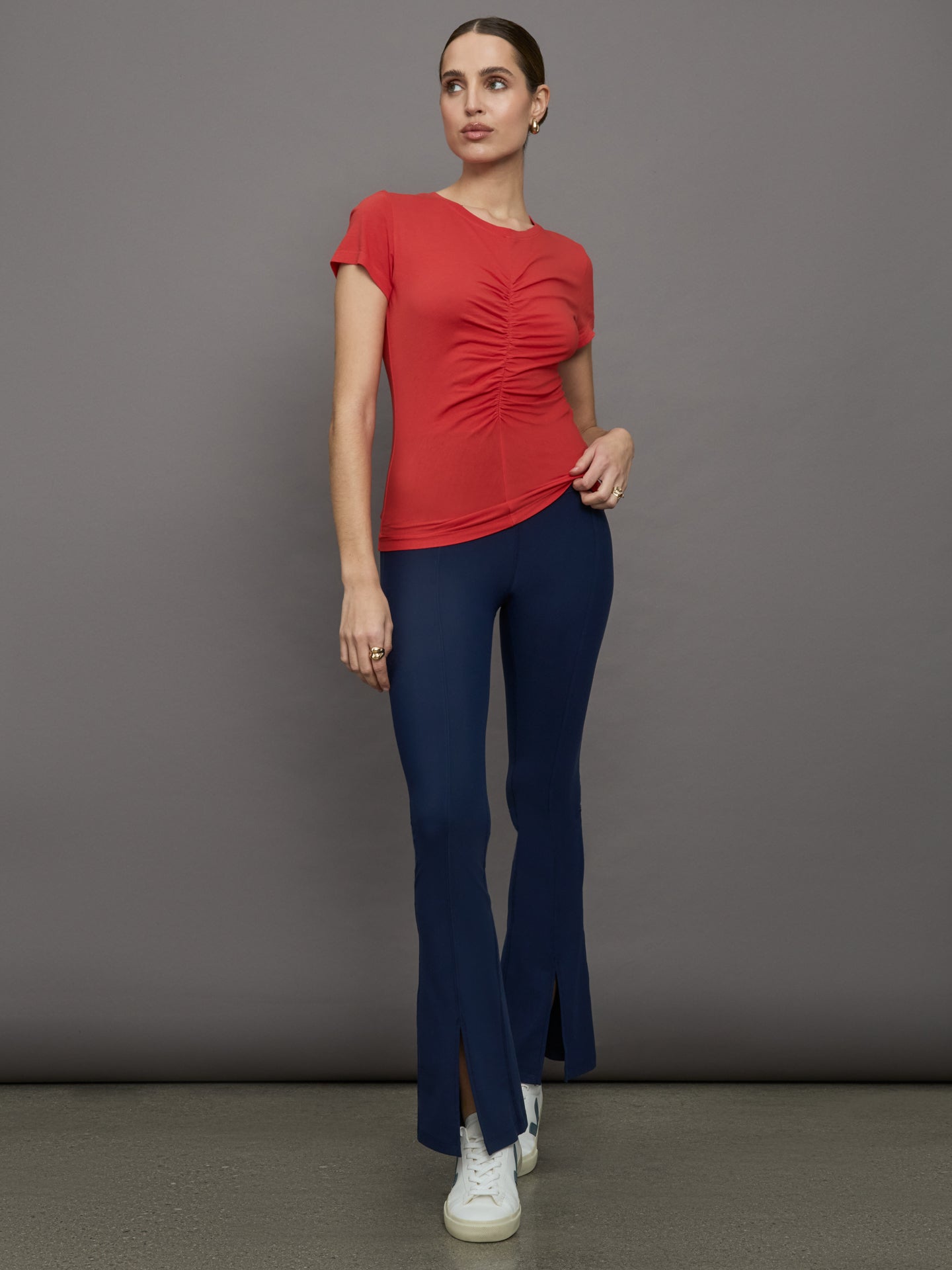 Model wears red short sleeve T-shirt with ruching down the center of the chest until the belly button. 