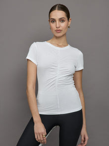 Model wears white short sleeve T-shirt with ruching down the center of the chest until the belly button. 