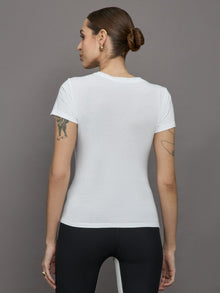 Model wears white short sleeve T-shirt with ruching down the center of the chest until the belly button. 