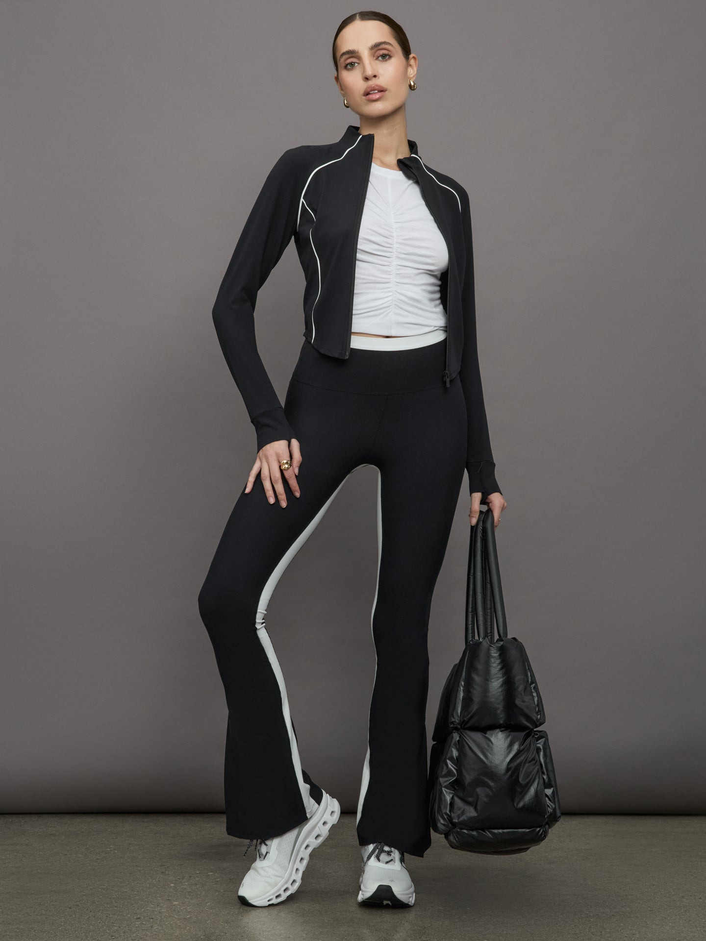 Model wears white short sleeve T-shirt with ruching down the center of the chest until the belly button. 