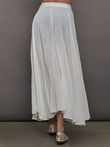 Back view of model in Mesh Pleated Skirt Ivory with flowy silhouette.