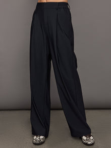 Model wears a pair of black wide leg versatile trousers. 