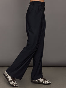 Model wears a pair of black wide leg versatile trousers. 