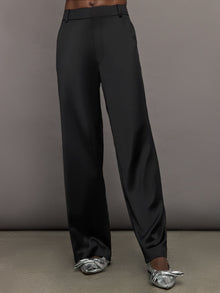 Model wears black satin pants with a relaxed fit.
