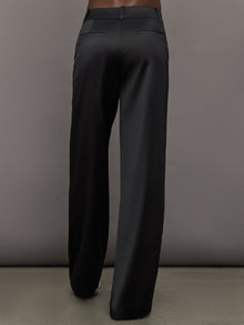 Model wears black satin pants with a relaxed fit.
