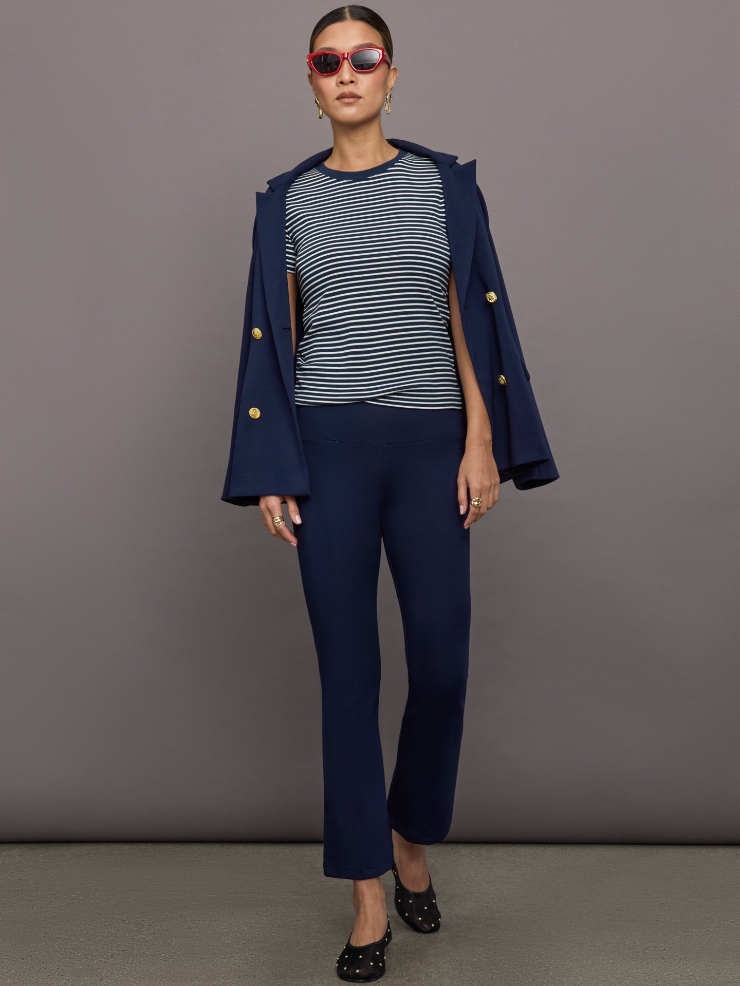 Navy high-rise pants with a fitted, sculpting silhouette through the hips and thighs, flaring out subtly at the hem.