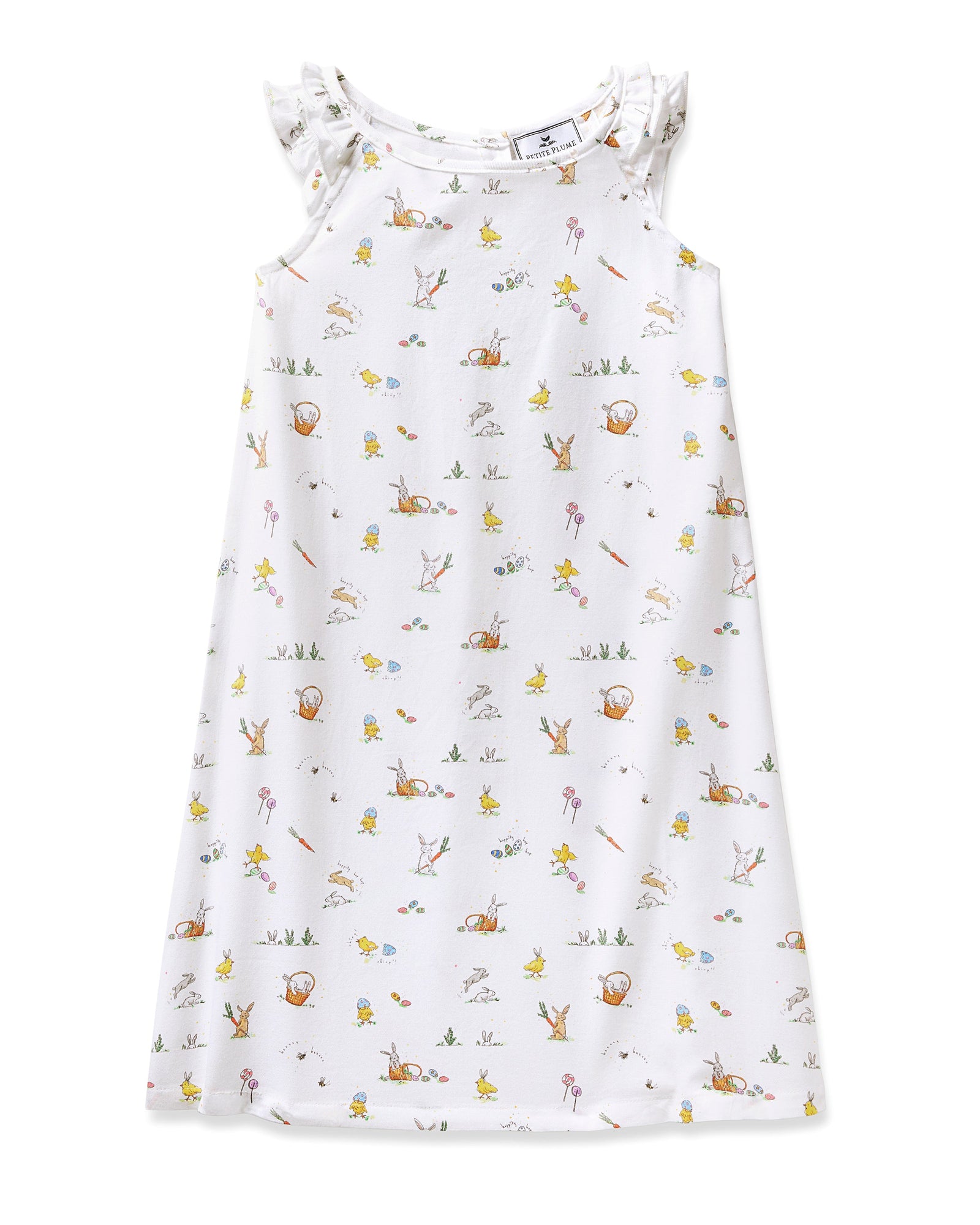 A young girl with short brown hair smiles in the Girl's Twill Amelie Nightgown in Easter Frolic, a white sleeveless dress featuring playful animal and nature prints, standing against a plain light background.