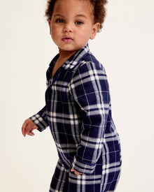 The Baby's Brushed Twill Classic Romper in Oxford Tartan is a full-length, long-sleeve children's onesie featuring a navy, white, and gray plaid pattern with a button-up front, collar, and snap leg closures.