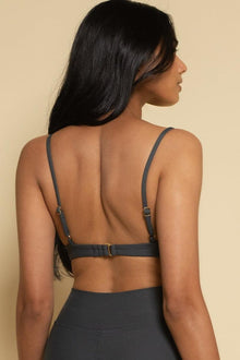 Charcoal bikini top with thin shoulder straps and back buckle detail, shown from behind on model.